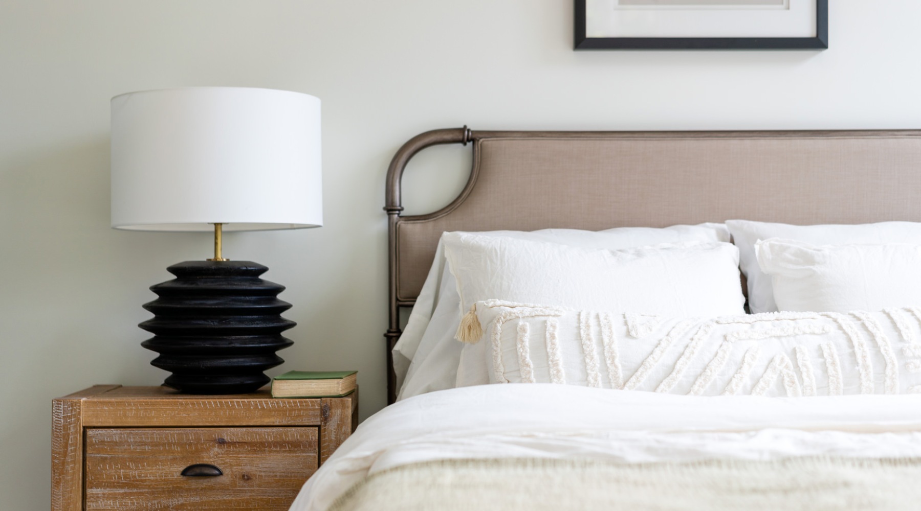 a bedroom with a nightstand and lamp on it