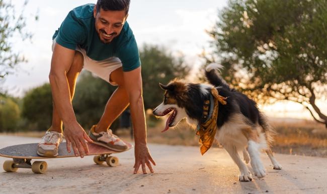 a person on a skateboard and a dog